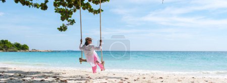 Téléchargez les photos : Femme asiatique sur une balançoire à la plage de Koh Samet Island Rayong Thaïlande, la plage tropicale blanche de Samed Island avec une turque couleur océan par un après-midi ensoleillé - en image libre de droit