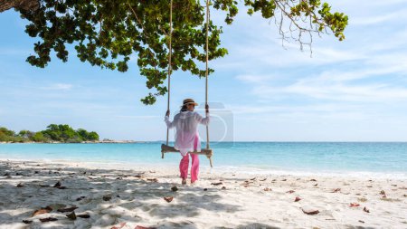 Téléchargez les photos : Koh Samet Island Rayong Thaïlande, la plage tropicale blanche de l'île de Samed avec un océan de couleur turque, femme asiatique sur une balançoire sur la plage regardant l'océan - en image libre de droit