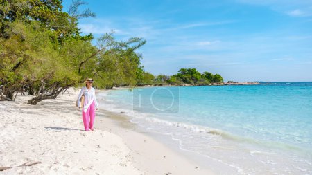 Photo for Asian Thai woman walking on the beach of Koh Samet Island Rayong Thailand, the white tropical beach of Samed Island with a turqouse colored ocean - Royalty Free Image
