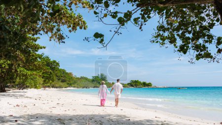 Téléchargez les photos : Un couple d'hommes et de femmes marchant sur la plage de Koh Samet Island Rayong Thaïlande, la plage tropicale blanche de Samed Island avec un océan de couleur turque - en image libre de droit