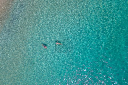 Photo for Aerial drone view from above at people swimming in the ocean at the Samed Island in Thailand, with a turqouse colored ocean and a white tropical beach view at Koh Samt Thailand - Royalty Free Image