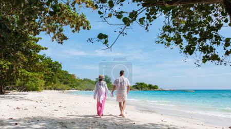 Téléchargez les photos : Un couple d'hommes et de femmes marchant sur la plage de Koh Samet Island Rayong Thaïlande, la plage tropicale blanche de Samed Island avec un océan de couleur turque - en image libre de droit