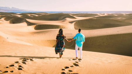 Photo for Couple walking at the beach of Maspalomas Gran Canaria Spain, men, and woman at the sand dunes desert of Maspalomas Gran Canaria - Royalty Free Image