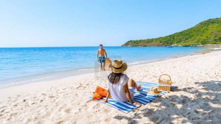 Téléchargez les photos : Koh Larn Island près de Pattaya Thaïlande, la plage tropicale de Koh Larn Thaïlande, une plage de sable blanc avec un océan d'eau claire. Tropical Island. un couple d'hommes se relaxant sur la plage avec un sup board - en image libre de droit