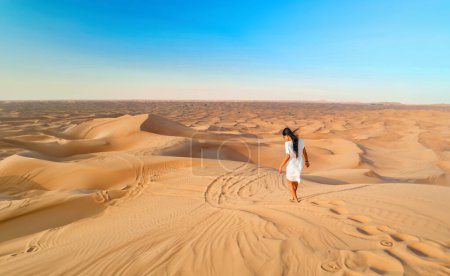 Foto de Dubai dunas de arena del desierto, una mujer asiática en Dubai safari desierto, Emiratos Árabes Unidos vacaciones, mujer de vacaciones en Dubai caminando por las dunas de arena de Dubai - Imagen libre de derechos