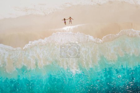 Photo for Man and woman lying down on a tropical beach, Drone view from above at a tropical beach in the Seychelles Cocos Island, view from above at a tropical beach, a couple on vacation tropical Island - Royalty Free Image
