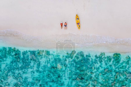 Foto de Vista del dron en pareja acostado en la playa de Koh Phi Phi Tailandia durante las vacaciones con un kayak. pareja en una playa con un kayak en Tailandia en Koh Phi Phi Krabi - Imagen libre de derechos