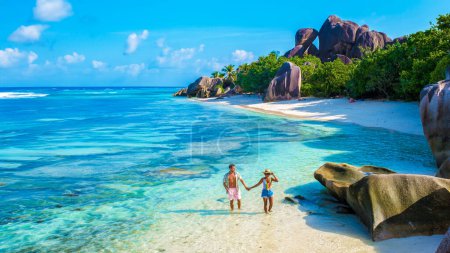 Foto de Anse Source d 'Argent, La Digue Seychelles, una joven pareja de hombres y mujeres en una playa tropical durante unas vacaciones de lujo en Seychelles. Playa tropical Anse Source d 'Argent, La Digue Seychelles - Imagen libre de derechos