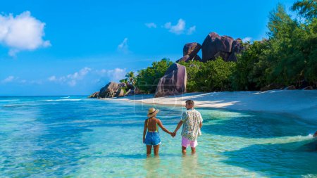 Téléchargez les photos : Anse Source d'Argent, La Digue Seychelles, un jeune couple d'hommes et de femmes sur une plage tropicale pendant des vacances de luxe aux Seychelles. - en image libre de droit