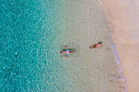 Téléchargez les photos : Vue par drone d'un homme et d'une femme nageant dans l'océan bleu turqouse de l'île de Koh Kradan en Thaïlande. vue de dessus sur la plage de Koh Kradan Trat Thaïlande - en image libre de droit