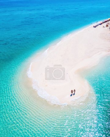 Téléchargez les photos : Hommes et femmes marchant sur un banc de sable dans l'océan de Koh Lipe sud de la Thaïlande pendant les vacances. un couple sur un banc de sable dans un océan de couleur turque - en image libre de droit