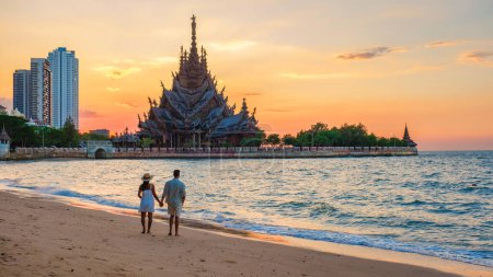 Téléchargez les photos : Un couple multiethnique diversifié d'hommes et de femmes visitent le temple en bois du Sanctuaire de la Vérité à Pattaya Thaïlande. - en image libre de droit