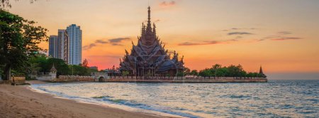 Photo for The Sanctuary of Truth wooden temple in Pattaya Thailand at sunset by the ocean beach of Pattaya - Royalty Free Image