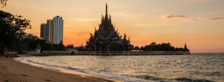 Photo for The Sanctuary of Truth wooden temple in Pattaya Thailand is a gigantic wooden construction located at the cape of Naklua Pattaya City Chonburi Thailand at sunset from the beach - Royalty Free Image
