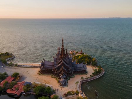 Photo for Sunset by the ocean with The Sanctuary of Truth wooden temple in Pattaya Thailand is a gigantic wooden construction located at the cape of Naklua Pattaya City Chonburi Thailand - Royalty Free Image