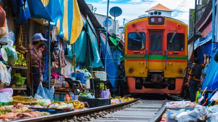 Foto de Mercado Ferroviario de Maeklong Tailandia, Tren en las vías de movimiento Paraguas lento Mercado fresco en la vía férrea, Estación de tren de Mae Klong, Bangkok un famoso mercado ferroviario en Tailandia - Imagen libre de derechos