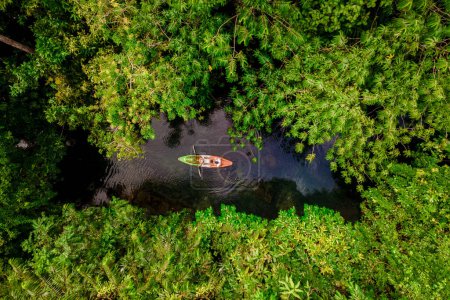 Foto de Couple in a kayak in the jungle of Krabi Thailand, men and women in a kayak in a tropical jungle in Krabi mangrove forest. - Imagen libre de derechos