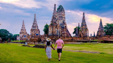 Téléchargez les photos : Hommes et Femmes avec chapeau touristes visitent Ayutthaya Thaïlande à Wat Chaiwatthanaram pendant le coucher du soleil, Couple sur un voyage à la vieille ville d'Ayutthaya - en image libre de droit