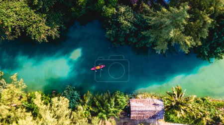 Photo for Couple men and women peddling in a kayak during the afternoon at sunset, People in a Kayak at a river klong of a tropical Island Koh Chang Thailand during sunset - Royalty Free Image