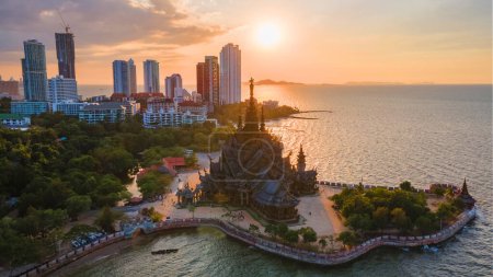 Photo for Skyline of Pattaya city at sunset with The Sanctuary of Truth wooden temple in Pattaya Thailand, drone aerial view at the wooden temple of Pattaya at sunset - Royalty Free Image
