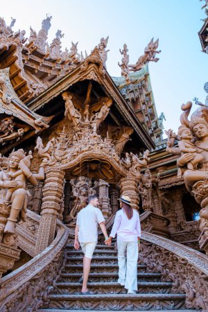 Foto de Una diversa pareja de hombres y mujeres visitan El Santuario de la Verdad templo de madera en Pattaya Tailandia. una construcción de templo de madera situada en el cabo de la ciudad de Naklua Pattaya Chonburi Tailandia - Imagen libre de derechos