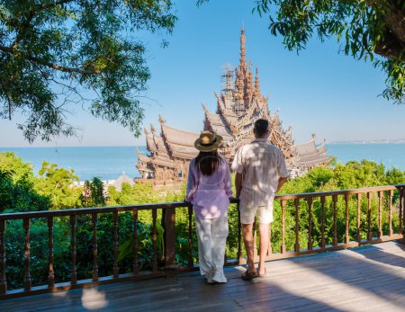 Foto de Un par de hombres y mujeres visitan El Santuario de la Verdad templo de madera en Pattaya Tailandia. una construcción de templo de madera situada en el cabo de la ciudad de Naklua Pattaya Chonburi Tailandia - Imagen libre de derechos