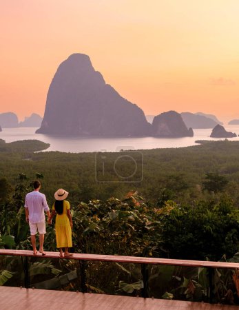 A couple of men and woman watching the sunrise at Sametnangshe viewpoint in Phangnga Bay Phangnga, Thailand