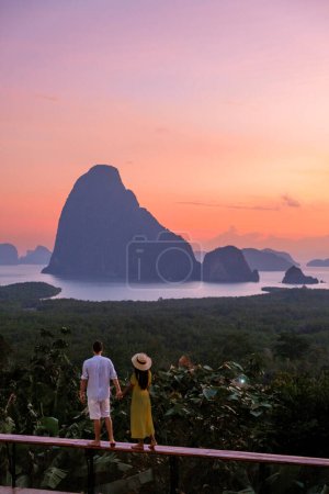 A couple of men and woman watching the sunrise at Sametnangshe viewpoint in Phangnga Bay with mangrove forest in the Andaman Sea , Sametnangshe travel destination in Phangnga, Thailand
