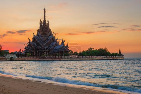 Téléchargez les photos : Le sanctuaire de la vérité temple en bois au coucher du soleil à Pattaya Thaïlande vue de la plage par l'océan - en image libre de droit