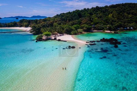 Photo for Couple walking at the beach of Koh Kham Trat Thailand, aerial drone view of the tropical island near Koh Mak Thailand. white sandy beach with palm trees and big black boulder stones in the ocean - Royalty Free Image