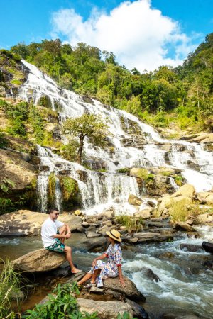 Photo for Mae Ya Waterfall Doi Inthanon National Park Thailand Chiang Mai is a beautiful waterfall in Doi Inthanon National Park in Thailand. A couple of men and a woman visiting a waterfall in Thailand - Royalty Free Image