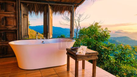 Foto de Bañera con vistas a las montañas de Chiang Rai norte de Tailandia durante las vacaciones. Baño exterior, bañera al atardecer - Imagen libre de derechos