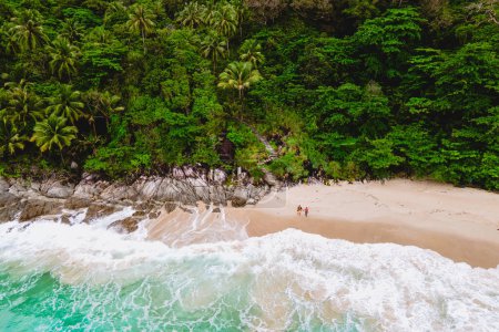 Foto de Un par de hombres y mujeres se están relajando en una playa tropical blanca con palmeras en Phuket Tailandia. Freedom Beach Phuket en un día soleado una playa tropical oculta - Imagen libre de derechos
