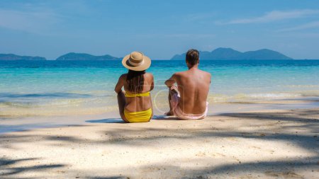 Téléchargez les photos : Koh Wai Island Trat Thaïlande est une île tropicale minuscule près de Koh Chang. un jeune couple d'hommes et de femmes sur une plage tropicale pendant des vacances de luxe en Thaïlande, couple couché sur la plage - en image libre de droit