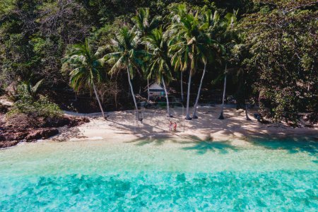 Téléchargez les photos : Koh Wai Island Trat Thaïlande près de Koh Chang. bungalow en bois de cabane de bambou sur la plage. un jeune couple d'hommes et de femmes sur la plage avec des palmiers sur une île tropicale en Thaïlande - en image libre de droit