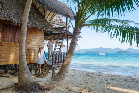 Téléchargez les photos : Koh Wai Island Trat Thaïlande une île tropicale près de Koh Chang. cabane en bois de bambou sur la plage. un jeune couple d'hommes et de femmes sur une île tropicale en Thaïlande regardant au-dessus de l'océan - en image libre de droit