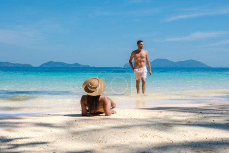 Téléchargez les photos : Koh Wai Island Trat Thaïlande près de Koh Chang Trat. Un jeune couple d'hommes et de femmes sur une plage tropicale pendant des vacances de luxe en Thaïlande se détendre sur la plage avec turqouse couleur océan - en image libre de droit