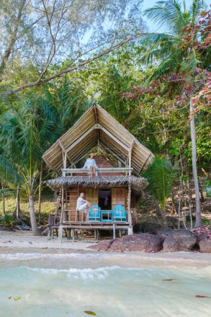 Photo for Koh Wai Island Trat Thailand is a tinny tropical Island near Koh Chang. wooden bamboo hut bungalow on the beach. a young couple of men and woman at a bamboo hut on a tropical Island in Thailand - Royalty Free Image