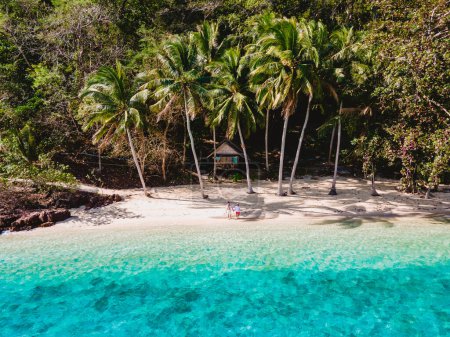 Téléchargez les photos : Koh Wai Island Trat Thaïlande, bungalow en bambou sur la plage. un jeune couple d'hommes et de femmes sur une île tropicale en Thaïlande avec des palmiers sur la plage et turqouse couleur océan - en image libre de droit