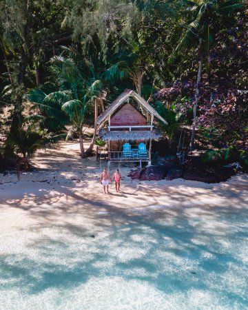 Téléchargez les photos : Koh Wai Island Trat Thaïlande île tropicale près de Koh Chang. bungalow en bois de cabane de bambou sur la plage. un jeune couple d'hommes et de femmes sur une île tropicale en Thaïlande avec une turque couleur océan - en image libre de droit