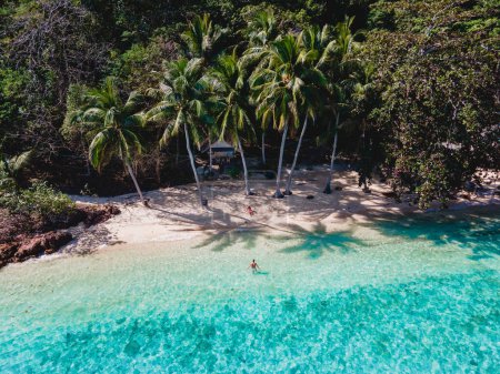 Téléchargez les photos : Koh Wai Island Trat Thaïlande. bungalow en bois de cabane de bambou sur la plage. un jeune couple d'hommes et de femmes sur une île tropicale en Thaïlande avec des palmiers sur la plage et un océan de couleur turque - en image libre de droit