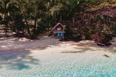 Téléchargez les photos : Koh Wai Island Trat Thaïlande près de Koh Chang. bungalow en bois de cabane de bambou sur la plage. un jeune couple d'hommes et de femmes se relaxant dans leur cabane en bambou sur une île tropicale en Thaïlande - en image libre de droit