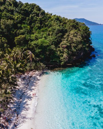 Téléchargez les photos : Drone vue aérienne à Koh Wai Island Trat Thaïlande. un jeune couple d'hommes et de femmes marchant sur une plage tropicale avec un océan bleu pendant des vacances de luxe en Thaïlande - en image libre de droit