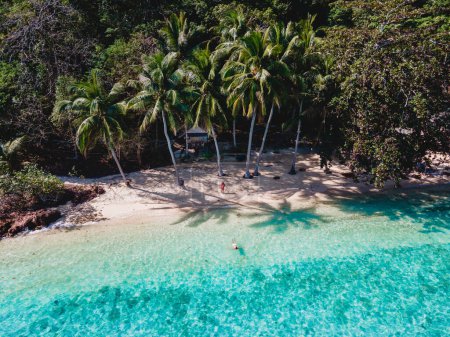 Téléchargez les photos : Bungalow en bois de cabane de bambou sur la plage avec un océan de couleur turqouse. un jeune couple d'hommes et de femmes sur une île tropicale en Thaïlande en vacances, Koh Wai Island Trat Thaïlande - en image libre de droit