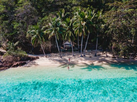 Téléchargez les photos : Bungalow en bois de cabane de bambou sur la plage avec un océan de couleur turqouse. un jeune couple d'hommes et de femmes sur une île tropicale en Thaïlande en vacances, Koh Wai Island Trat Thaïlande - en image libre de droit