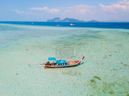 Téléchargez les photos : Bateau à queue longue dans l'océan de couleur turque avec de l'eau claire à Koh Kradan une île tropicale à Trang en Thaïlande - en image libre de droit