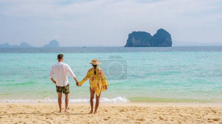 Téléchargez les photos : Joyeux jeune couple, une femme asiatique et des hommes européens sur la plage de l'île de Koh Ngai, sable blanc doux, et un océan de couleur turque à Koh Ngai Trang Thaïlande - en image libre de droit