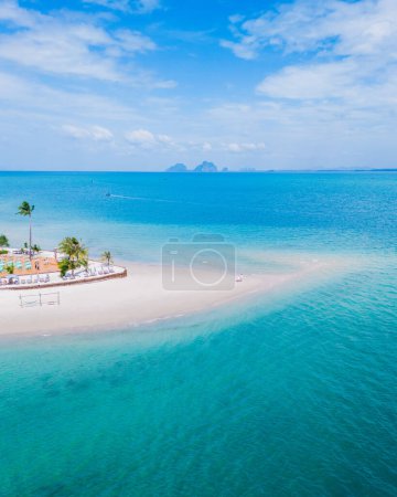 Foto de Vista aérea del dron en Koh Muk una isla tropical con palmeras de suave arena blanca, y un océano de color turquesa en Koh Mook Trang Tailandia, una pareja en un banco de arena en el océano en un día soleado - Imagen libre de derechos