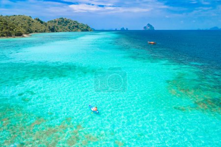 Photo for Young man in a kayak at the bleu turqouse colored ocean of Koh Kradan a tropical island with a coral reef in the ocean, Koh Kradan Trang Thailand - Royalty Free Image