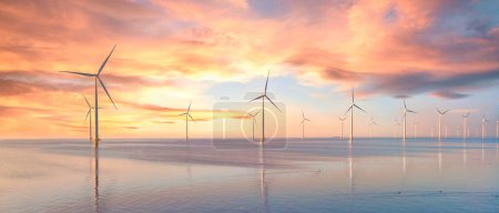 Foto de Parque de molinos de viento en el océano, vista aérea de drones de turbinas de molinos de viento que generan energía verde eléctricamente, molinos de viento aislados en el mar en los Países Bajos al atardecer - Imagen libre de derechos